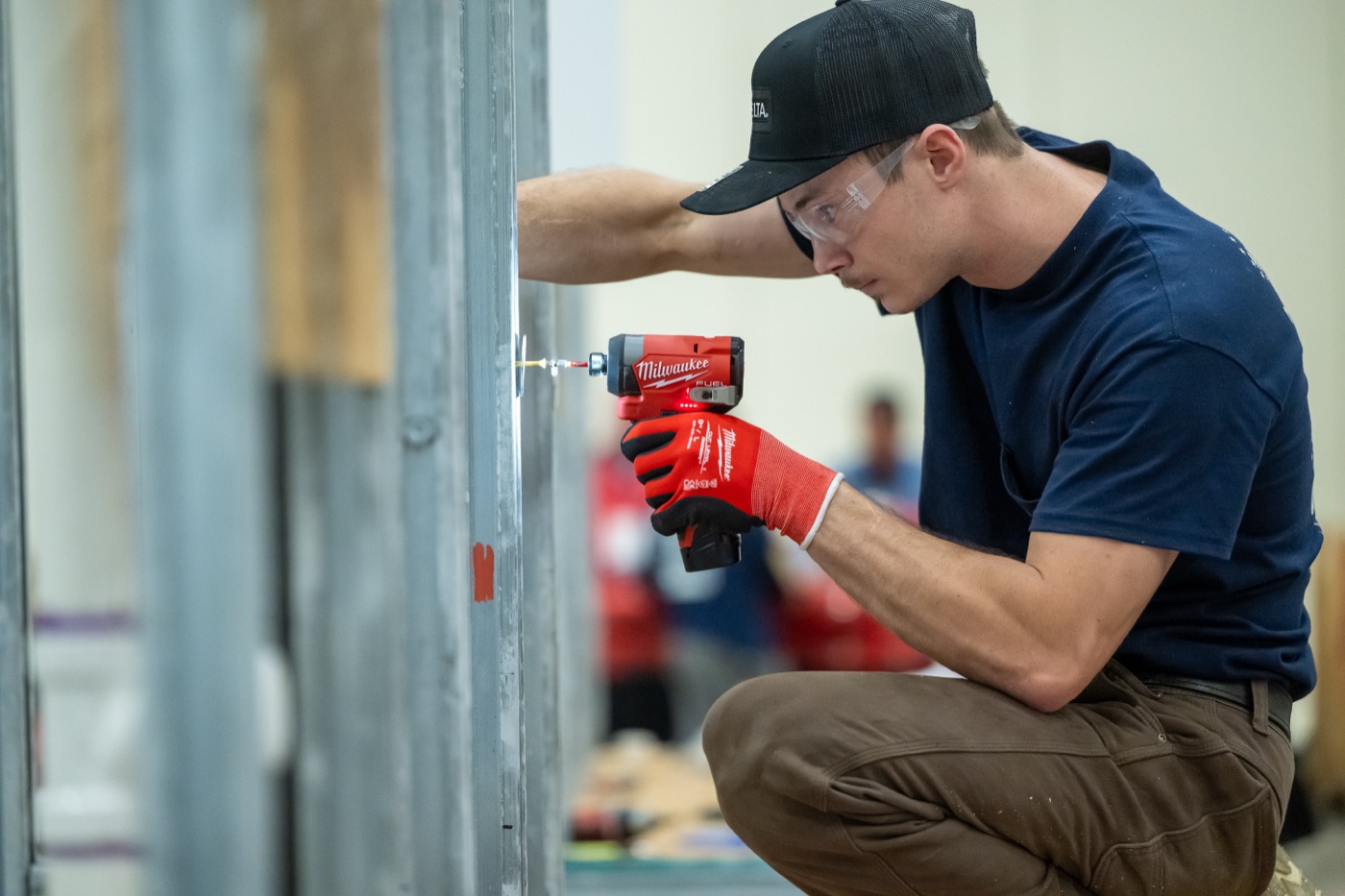 Apprentice driving fasteners with a Milwaukee impact driver at the national contest
